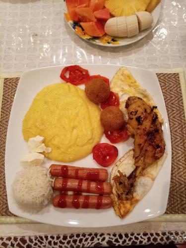 Een bord met ontbijtproducten zoals eieren, worst en groenten. bij Mendis Villa in Kosgoda