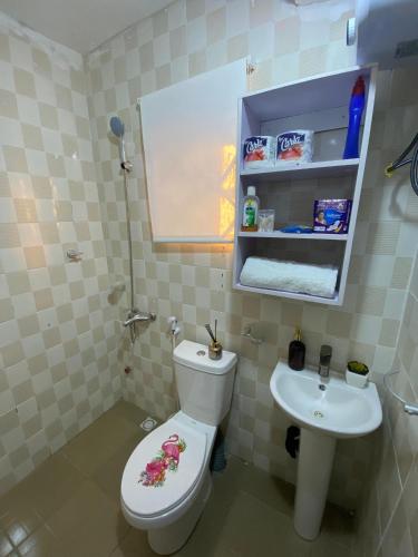 a bathroom with a toilet and a sink at The Flamingo 2 in Jos