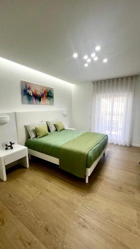 a bedroom with a large green bed and a window at Dorado Home in Scafati