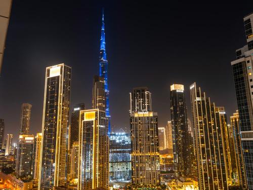 a view of a city skyline at night at 5 Star High Rise Luxury Apartment, Infinity Pool With Stunning Burj View - Brand New Apartment in Dubai