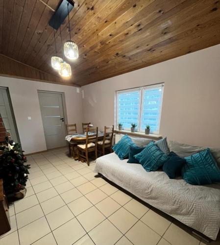 a living room with two beds and a table at Domek letniskowy Podamirowo in Podamirowo