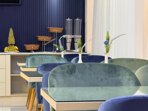 a room with blue chairs and tables with plants at Musafir Hotel in Tashkent