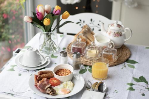 un tavolo per la colazione con un piatto di cibo e fiori di The Mayfield Hotel a Blackpool