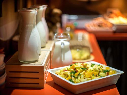 a table with a bowl of food and a bottle of milk at Ibis Riga Centre in Rīga