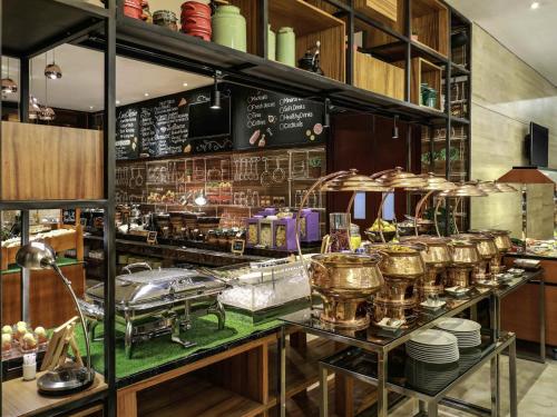 雅加达雅加达茨基尼美居酒店的厨房配有带许多锅碗瓢盆的柜台