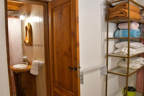a bathroom with a closet with a sink and towels at Girgola hospedaje in Villa Pehuenia