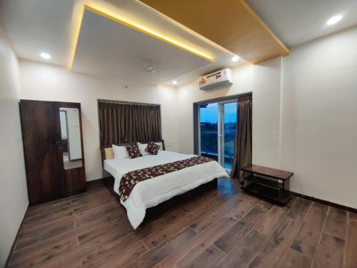 a bedroom with a large bed and a large window at RT RESIDENCY HOTEL and LODGE in Nandurbār