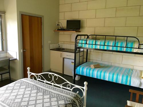 a room with two bunk beds and a kitchen at Port Campbell Guesthouse & Flash Packers in Port Campbell