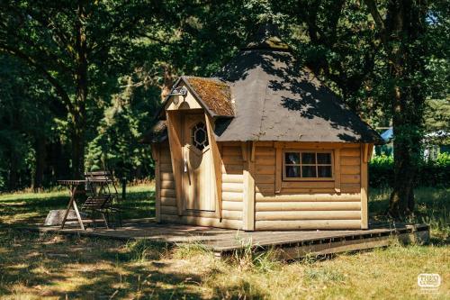 een klein houten huis met een dak bij camping de brocéliande in Néant-sur-Yvel