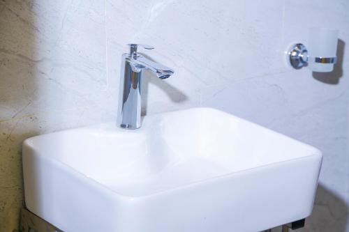 ein Waschbecken mit einem Wasserhahn darüber in der Unterkunft My Hill Eco Lodge in Ruhengeri