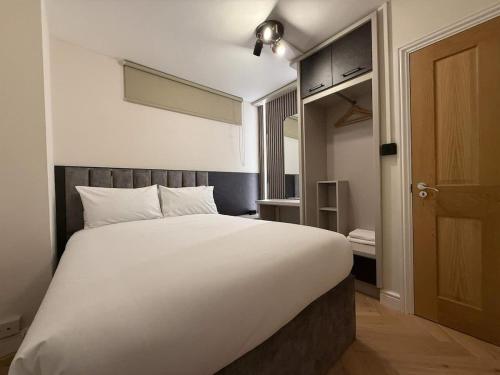 a large white bed in a room with a door at Fantastic Two Bed Flat In Paddington Central London Zone 1 in London