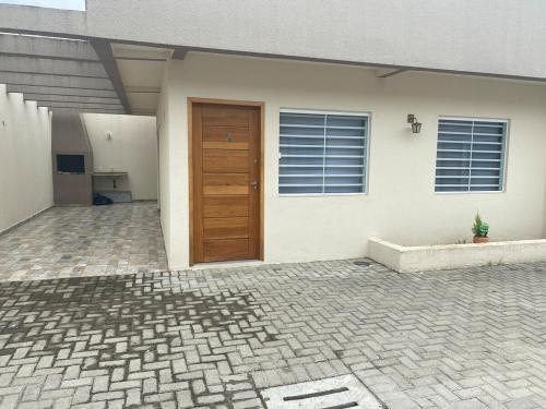 una casa con porta in legno e patio di Casa da Praia Edmara a Guaratuba