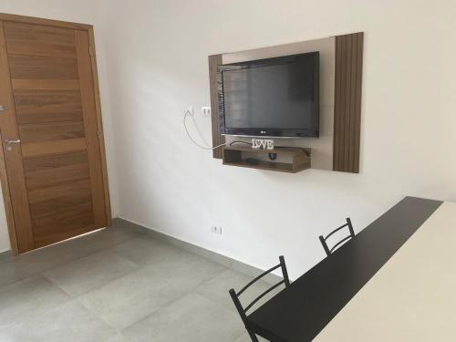 una stanza con una TV a schermo piatto su una parete di Casa da Praia Edmara a Guaratuba