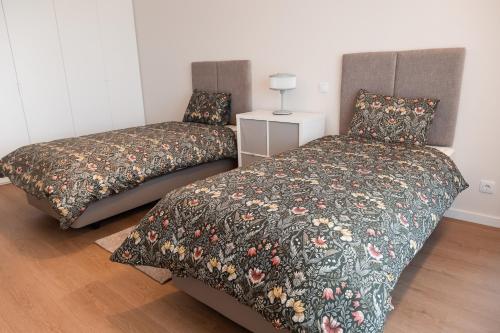 a bedroom with two beds and a lamp on a floor at Conserveira 8 in Olhão