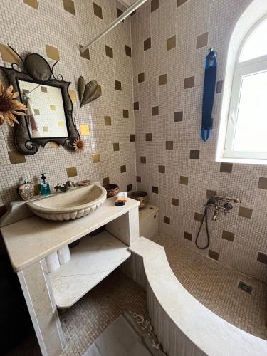 a bathroom with a sink and a bath tub at South Hammamet Pool Villa in Hammamet Sud