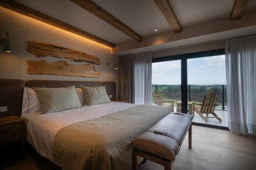 a bedroom with a large bed and a large window at Casa Pradera - Hotel Serrano in Sierra de los Padres