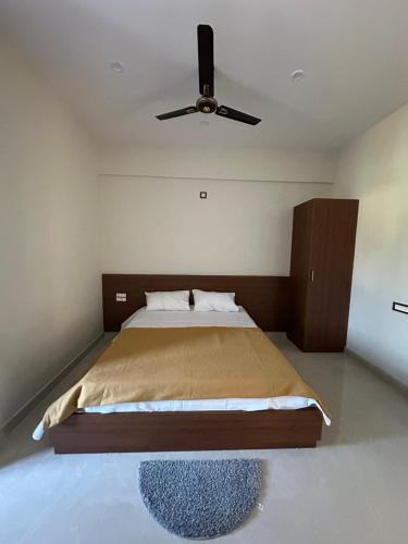 a bedroom with a bed with a ceiling fan at Nayana comforts in Nandigunda