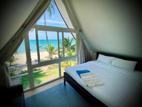 a bedroom with a bed with a view of the beach at Amore Villa by Utalay Koh Chang in Ban Khlong Son