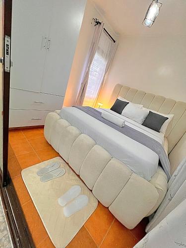 a large white bed in a room with a large white couch at Luxury small Homely Apt villa in Kisumu