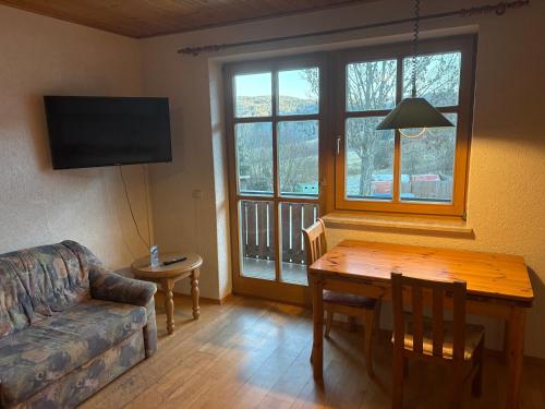 ein Wohnzimmer mit einem Tisch und einem Sofa in der Unterkunft Panorama Apartments in Lohberg