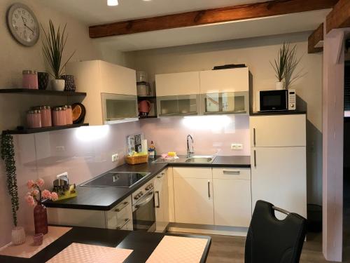 een keuken met witte kasten en een spoelbak bij Rennerhof-Siebeneichen Fewo Waschbär in Sulzbach-Rosenberg