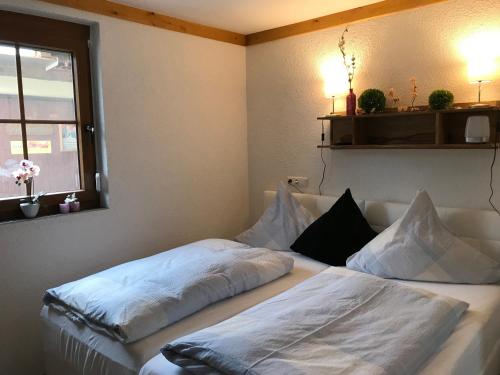 een slaapkamer met twee bedden met witte lakens en een raam bij Rennerhof-Siebeneichen Fewo Waschbär in Sulzbach-Rosenberg
