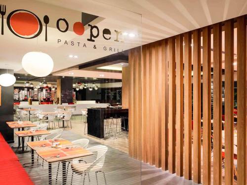 un ristorante con tavoli e sedie e un bar di Ibis Saigon Airport ad Ho Chi Minh