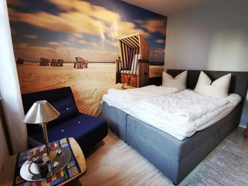 a bedroom with a large bed and a chair at ruhige 3-Raum-Wohnung "BODDENBLICK" mit Balkon und Terrasse in Zingst