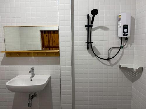 une salle de bains avec un lavabo et un miroir dans l'établissement Madee House - มาดีเฮ้าส์, 