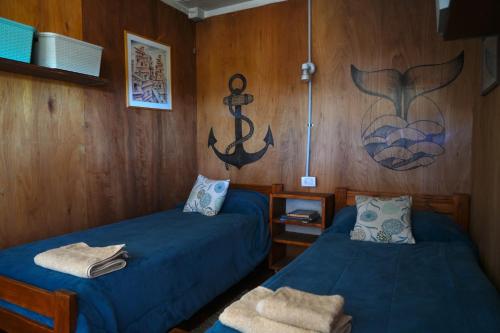 ein Zimmer mit zwei Betten und einem Gemälde an der Wand in der Unterkunft Chacra La Elena - Casa container a 15km de Madryn in Puerto Madryn