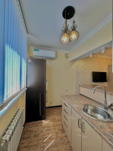 een keuken met een spoelbak en een zwarte koelkast bij Nice Stay Near Center in Jerevan
