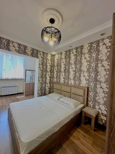 een slaapkamer met een bed en een kroonluchter bij Nice Stay Near Center in Jerevan