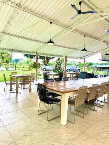 un grande tavolo in legno con sedie sotto un padiglione di Finca Hotel Buenos Aires a Guamal