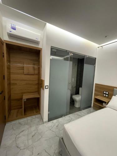 a bedroom with a bed and a bathroom with a shower at Hôtel kairouan in Fez