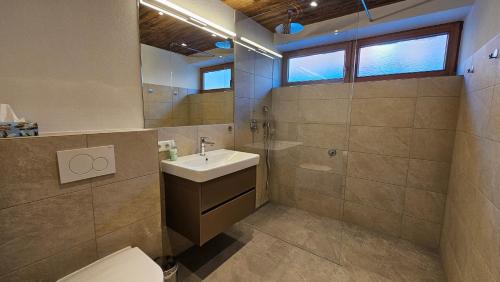 a bathroom with a sink and a toilet at Mountain Suite Brixen in Brixen im Thale