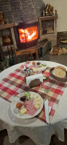 einen Tisch mit Teller mit Lebensmitteln auf einem Tisch und einem Kamin in der Unterkunft Guest House Popov in Marchevo