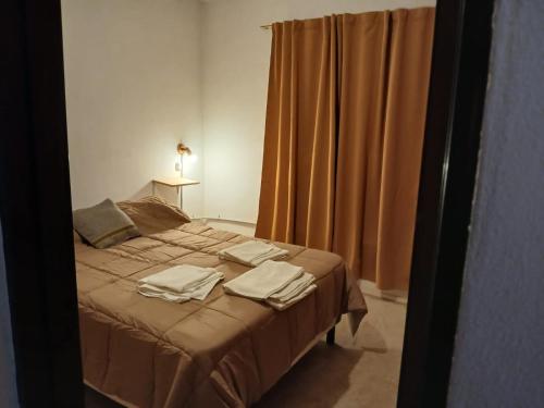una camera da letto con un letto con asciugamani sopra di Departamentos de Campo Solar de las Chacras a Juana Koslay 
