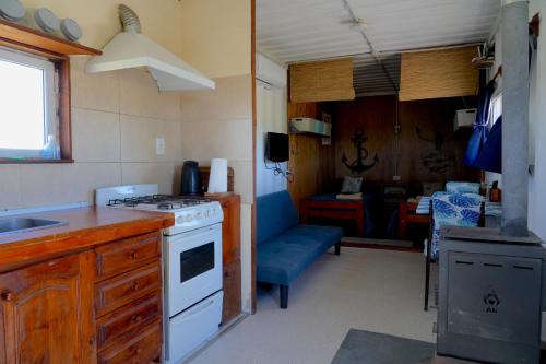 eine Küche mit Spüle und Herd Oberer Backofen in der Unterkunft Chacra La Elena - Casa container a 15km de Madryn in Puerto Madryn