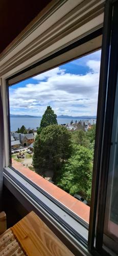 een raam met uitzicht op een boom bij El encanto del lago in Bariloche