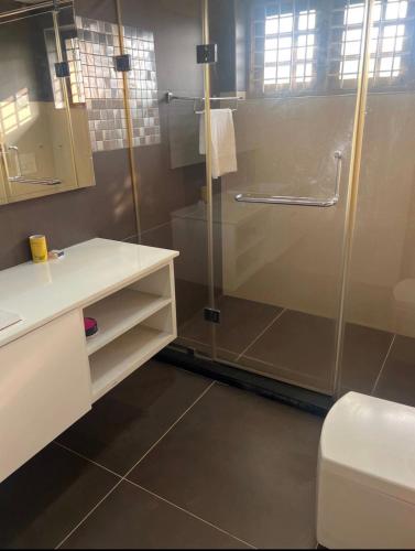 a bathroom with a glass shower and a toilet at Krishnamadom in Kollam