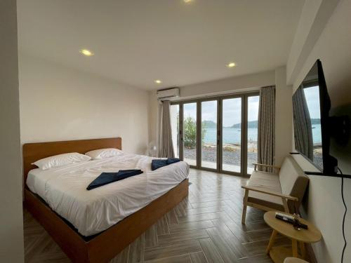 een slaapkamer met een bed en uitzicht op de oceaan bij Acacia Phuket in Nai Harn Beach