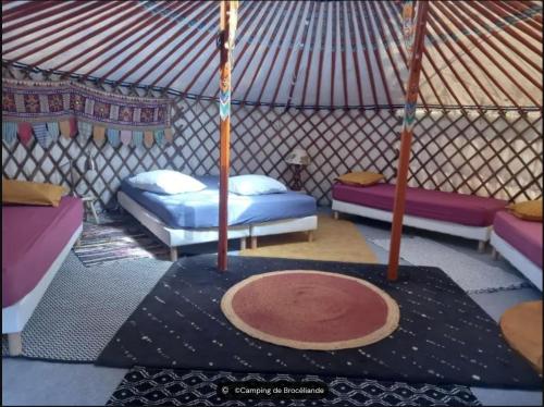een kamer met 3 bedden in een yurt bij camping de brocéliande in Néant-sur-Yvel
