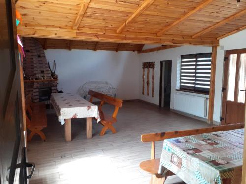 ein Wohnzimmer mit einer Holzdecke und einem Tisch in der Unterkunft Cabana Lac in Sadu