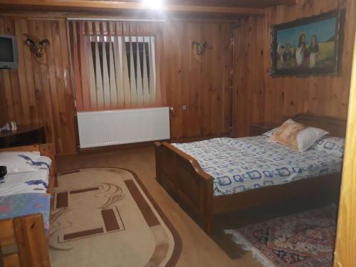 a small bedroom with a bed and a rug at Cabana Lac in Sadu