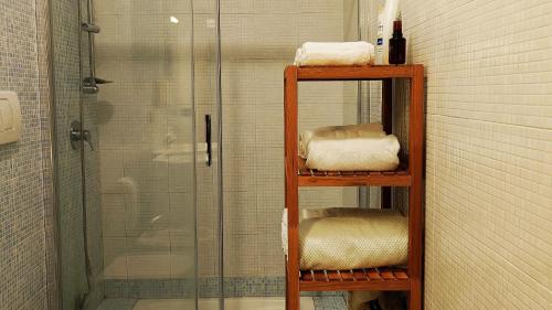 a bathroom with a shower and shelves with towels at Giro di Bitta in Giovinazzo