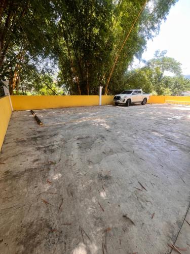 un'auto parcheggiata in un parcheggio accanto a una recinzione gialla di Acogedor Apartamento en Copán a Rovine di Copán