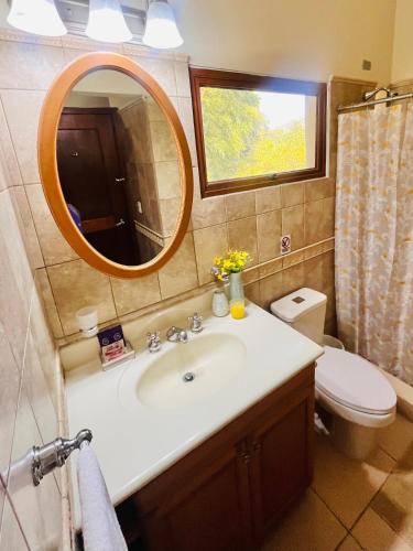 a bathroom with a sink and a mirror and a toilet at Acogedor Apartamento en Copán in Copán Ruinas