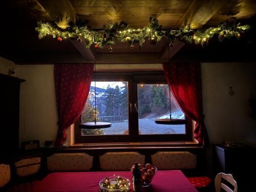 a room with a table with a window with christmas lights at Ferienwohnung Alpenlodge 52 in Aschau