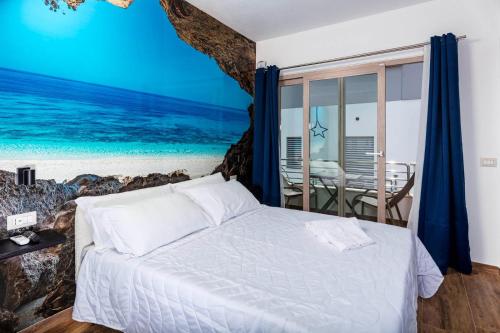 a bedroom with a bed with a painting of the ocean at Blue Bay rooms in Cala Gonone