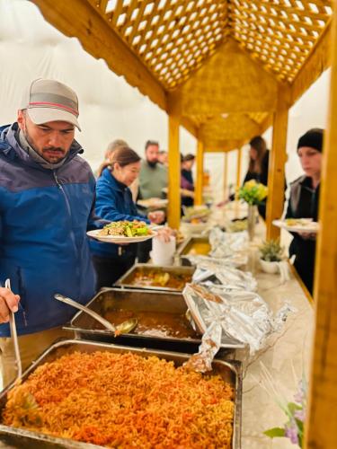 Un uomo in piedi di fronte a un buffet di cibo di Rum Laura luxury camp a Wadi Rum